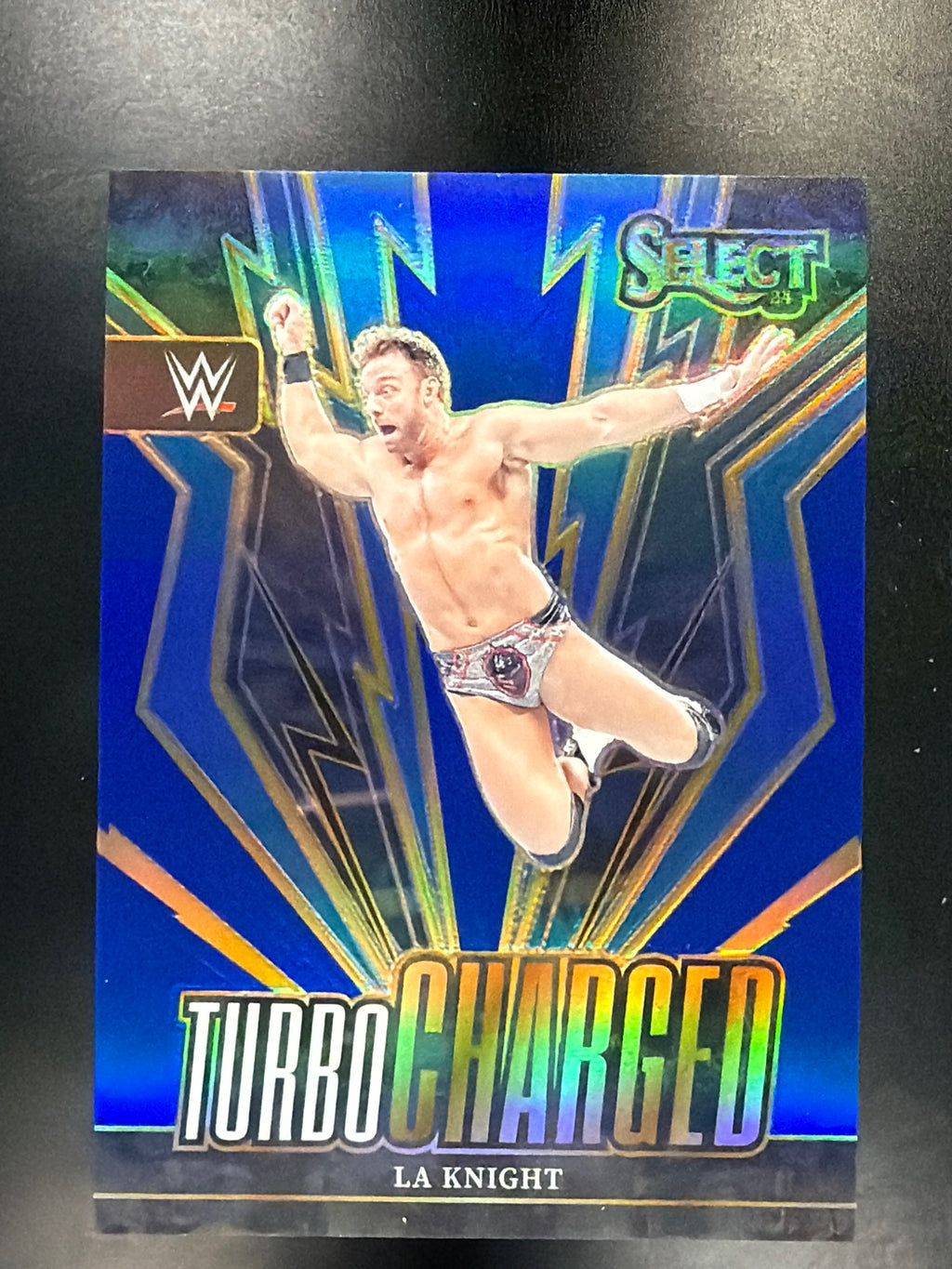 2024 Panini Select WWE #28 LA Knight Turbo Charged Blue Prizms #/49