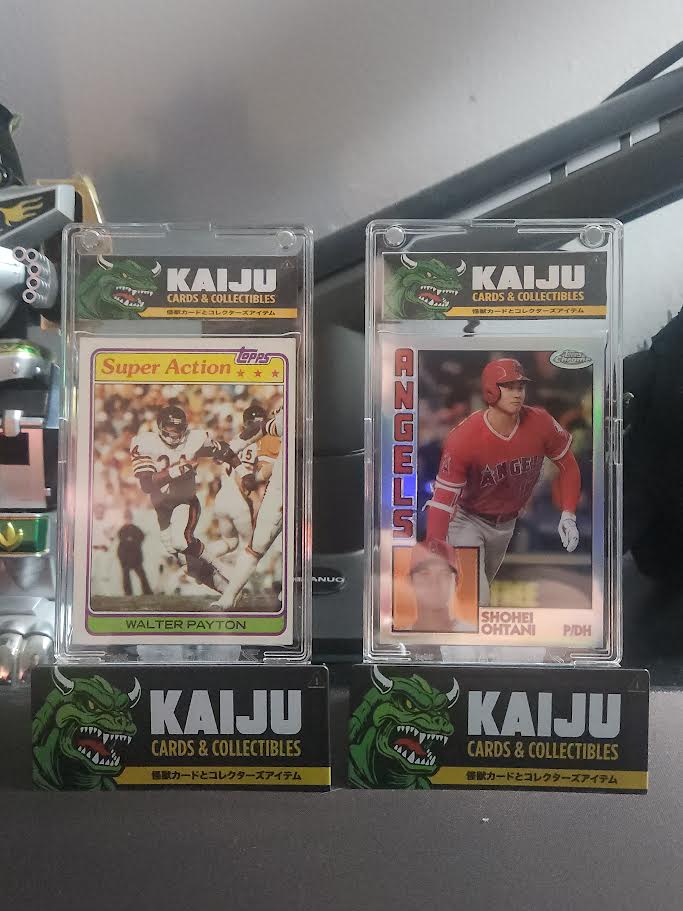 Walter Payton and Shohei Ohtani trading cards are displayed in clear cases with Kaiju Cards & Collectibles branding on a dark background.